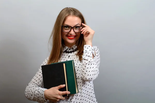 Retrato de jovem estudante com óculos segurando um livro velho sobre g — Fotografia de Stock