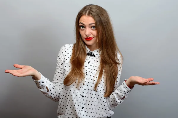 Endişeli kadın eller yaymak ve ne yapmak, üzerinde izole gri bilmiyor