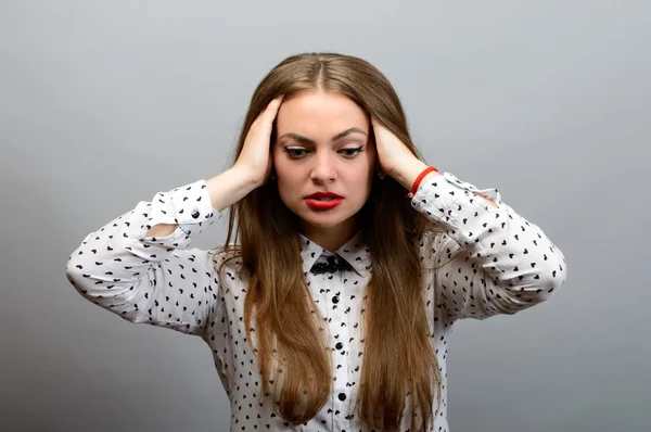 Portrait d'une jeune femme couvrant ses oreilles sur fond gris. Regardant la caméra — Photo