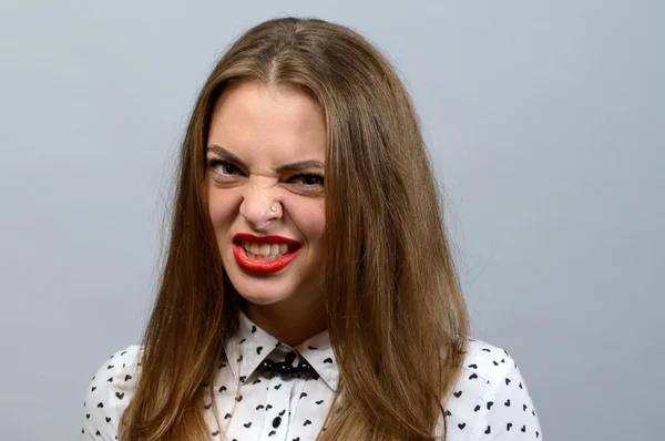 Chica enojada apretando los dientes contra el fondo gris —  Fotos de Stock