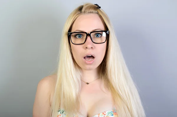 Şaşırtıcı bir kadın. Yakın plan portresi olan kadın tamamen inanamamasına şaşırmış görünüyor. Ağzı açık, izole gri duvar arkaplanı. Olumlu insani duygu yüz ifadesi vücut dili. Komik kız.