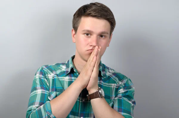 Närbild av man med lugn blick på kameran på grå bakgrund — Stockfoto