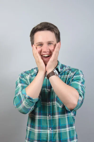 Joven guapo hombre sorprendido aislado sobre gris fondo — Foto de Stock