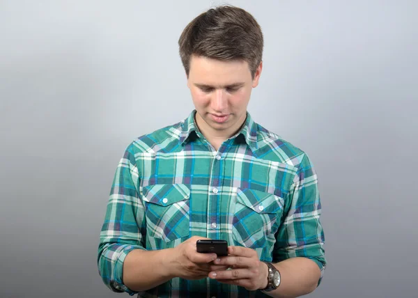 Glücklicher Mann mit Smartphone vor grauem Hintergrund — Stockfoto