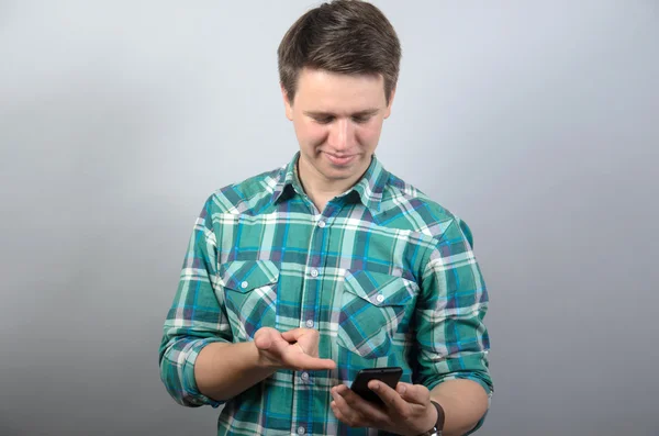 Hombre feliz usando teléfono inteligente sobre fondo gris — Foto de Stock