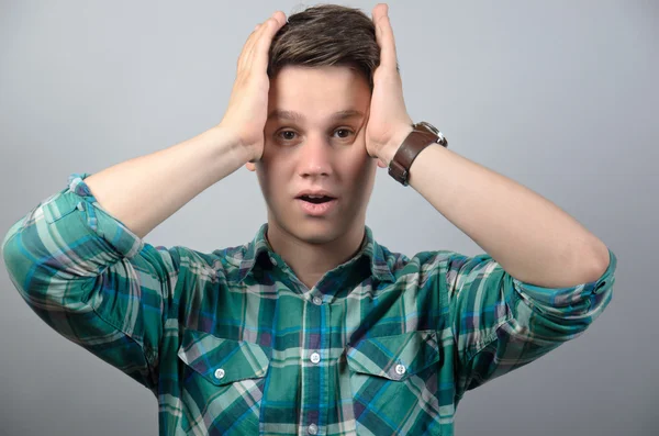 Portret van gefrustreerd man in shirt staande tegen de grijze achtergrond — Stockfoto