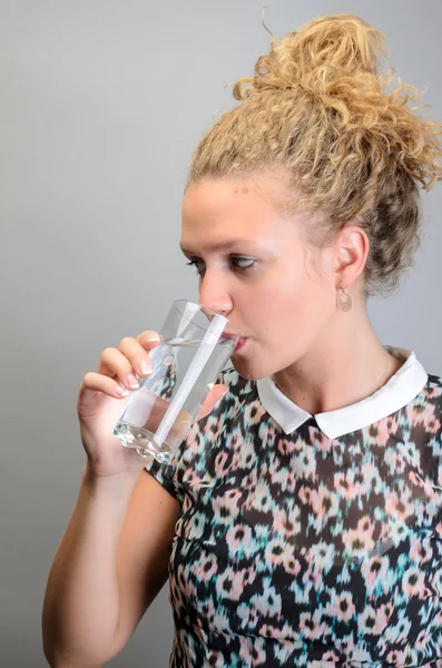 Giovane donna con vetro di acqua minerale isolato — Foto Stock