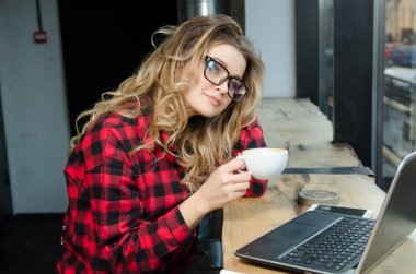 Sabahları restoranda kahve içen bir kadın.