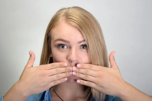 Piękna młoda kobieta obejmujące usta jej ręce — Zdjęcie stockowe