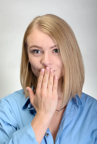 Schöne junge Frau, die den Mund mit ihrer Hand bedeckt — Stockfoto