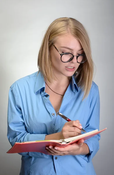 Jovem sorrindo mulher fazendo anotações — Fotografia de Stock