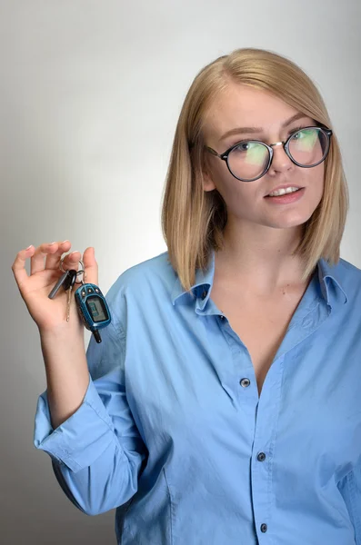 Una mujer con las llaves del coche. Aislado sobre fondo gris . —  Fotos de Stock