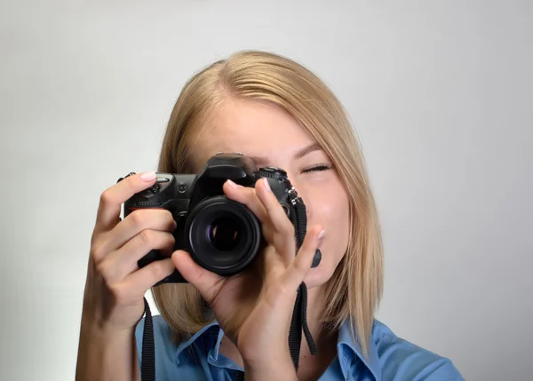 Jonge mooie vrouw met digitale camera op grijze achtergrond — Stockfoto