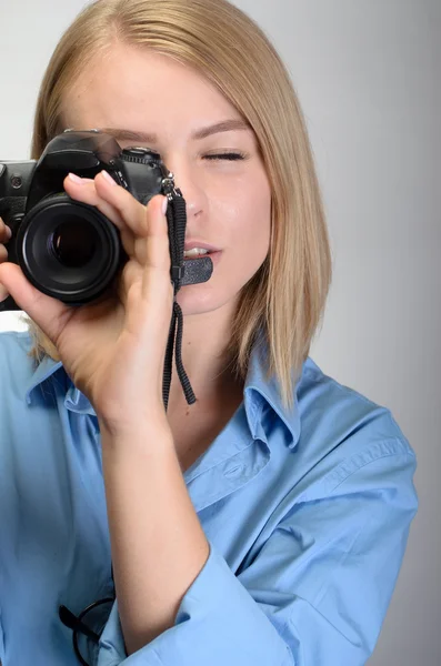 Jonge mooie vrouw met digitale camera op grijze achtergrond — Stockfoto