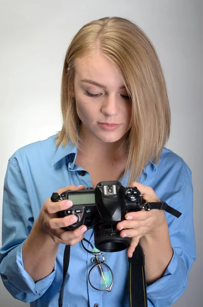 Jonge mooie vrouw met digitale camera op grijze achtergrond — Stockfoto