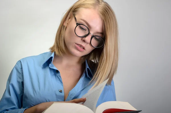 Jovem mulher bonita em óculos lendo um livro — Fotografia de Stock