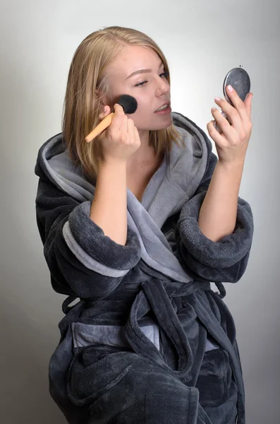 Retrato de mujer atractiva en albornoz haciendo su maquillaje — Foto de Stock