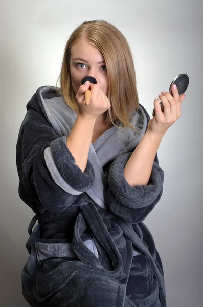 Retrato de mujer atractiva en albornoz haciendo su maquillaje —  Fotos de Stock