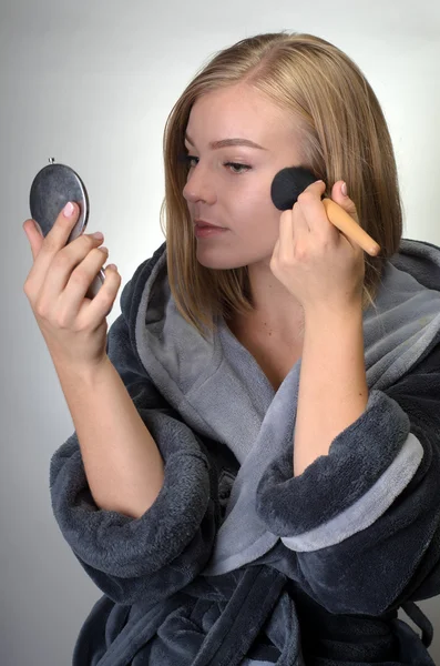 Retrato de mujer atractiva en albornoz haciendo su maquillaje —  Fotos de Stock