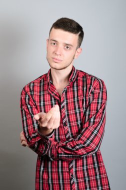 Kurnaz adam eliyle davet. Gri arka plan üzerinde izole portre