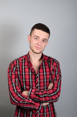 Gri arka plan üzerinde gülümseyen genç adam portresi