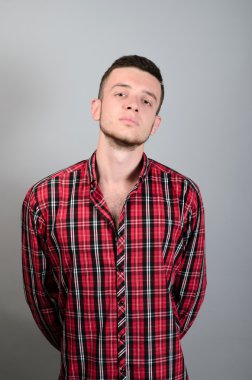 Gri arka planda, kurnaz, kızgın genç adam portresi