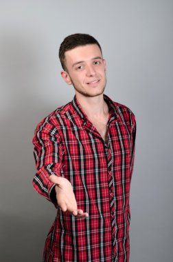 Genç güzel adam karşılıklı gri Studio için elini tutar