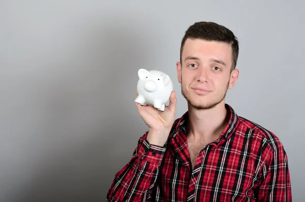 Hombre con Piggy moneybox aislado sobre fondo gris — Foto de Stock