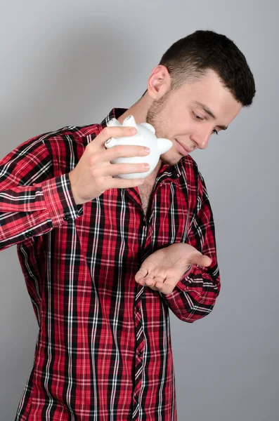 Hombre con Piggy moneybox aislado sobre fondo gris — Foto de Stock