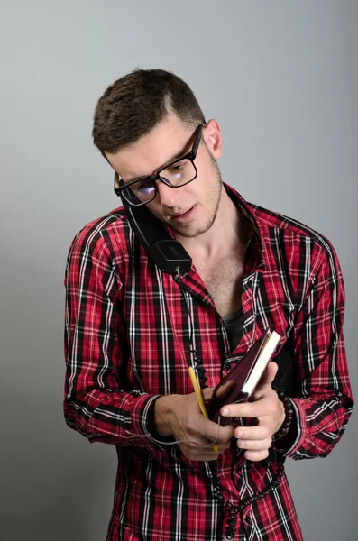 Joven hablando por teléfono fijo y escribiendo algo en la nota — Foto de Stock