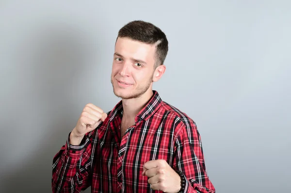 Boxning stativ. Den unge mannen i stående ställning på en grå bakgrund. — Stockfoto