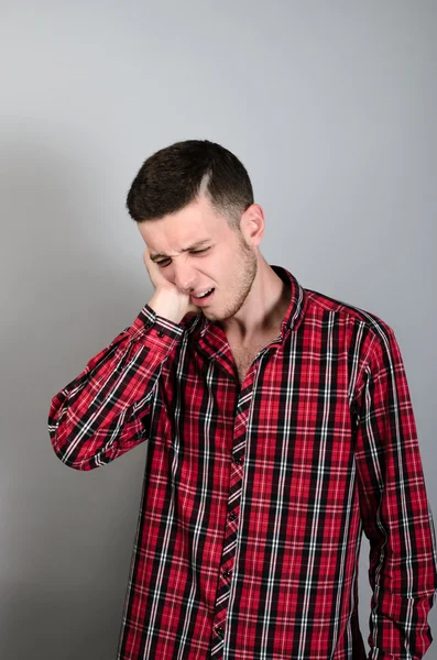 Der Mensch hat Zahnschmerzen. Auf grauem Hintergrund. — Stockfoto