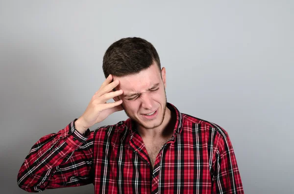 Porträt eines Mannes mit Kopfschmerzen auf grauem Hintergrund — Stockfoto
