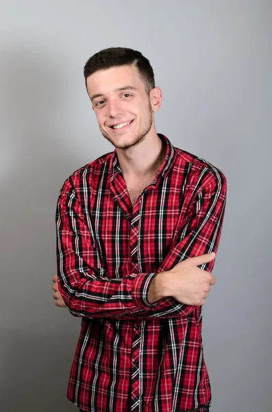 Porträtt av ung man leende på grå bakgrund — Stockfoto