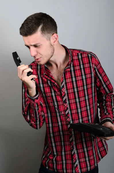 Homem de negócios irritado gritando em telefone fixo em cinza — Fotografia de Stock