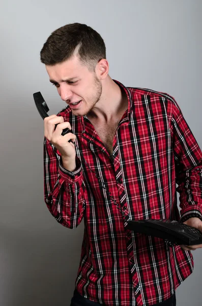 Homem de negócios irritado gritando em telefone fixo em cinza — Fotografia de Stock
