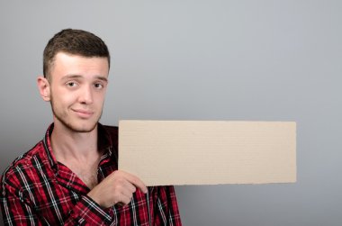 Metin veya slogan, gri arka plan için boşaltmak bulunduðu boş tabela gösterilen genç adam portresi