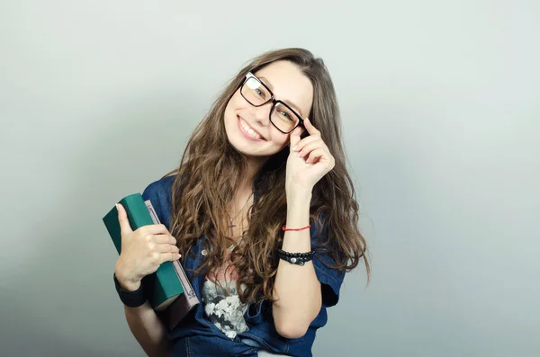 Kitap gri arka plan üzerinde tutan genç kadın