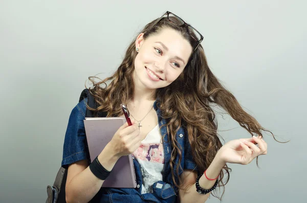 Jovem segurando livro no fundo cinza — Fotografia de Stock