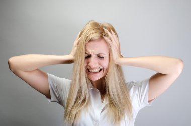 Bu çok yüksek. Kafa elinde tutan ve gözleri duran gri arka plan karşı kapalı tutarak resmi kıyafeti içinde sinir bozucu genç kadın