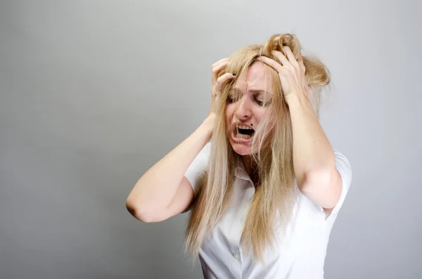 Junge Frau schreit vor Schmerz und hält ihren Kopf — Stockfoto