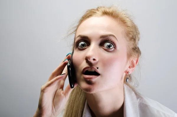 Choqué jeune femme obtenir de mauvaises nouvelles au téléphone — Photo