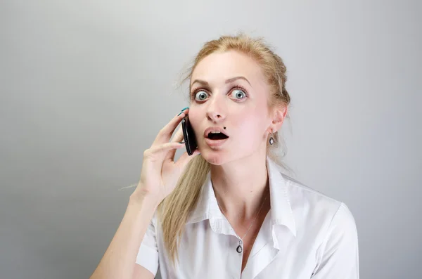 Schockierte junge Frau bekommt schlechte Nachrichten am Telefon — Stockfoto