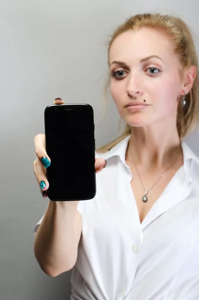 Young woman show display of mobile cell phone with black screen and smiling. Focus on hand with mobile phone