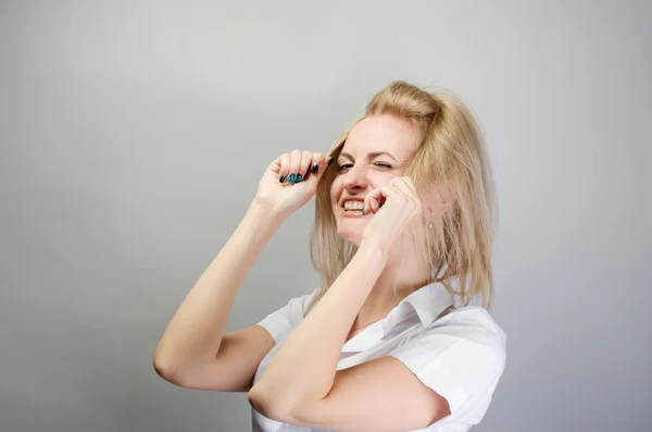 Молодая привлекательная счастливая смеющаяся блондинка делает волосы, упдо — стоковое фото
