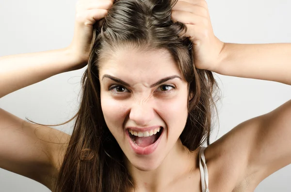 Closeup pose of an angry woman pulling her hair — Stock Photo, Image