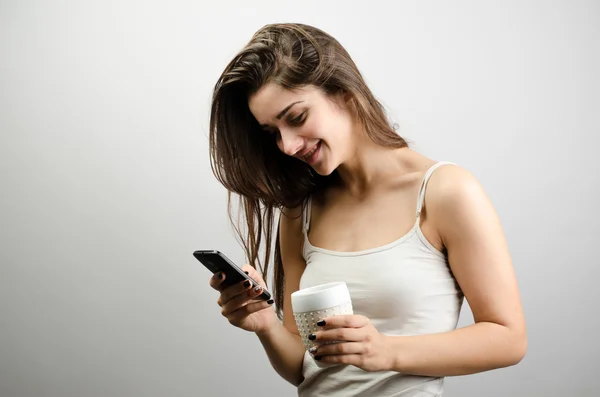 Mujer leyendo buenos sms en el teléfono inteligente beber té — Foto de Stock