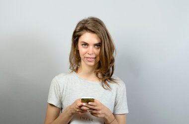 Kameraya bakarak bir akıllı telefon kullanan mutlu kadın