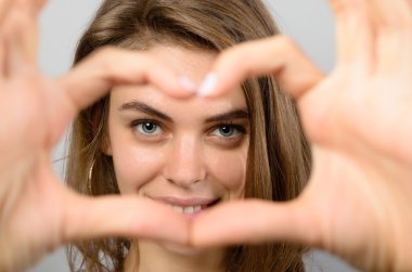 Romantik kadın kalp jest yapma o aşk ve sevgi duygularını gösterdiği gibi elleriyle onu çerçeveleme gözleri gülüyor
