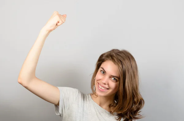 Gelukkige vrouw vieren haar overwinning op grijze achtergrond — Stockfoto